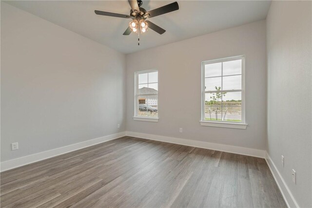 empty room featuring wood-type flooring, plenty of natural light, and ceiling fan