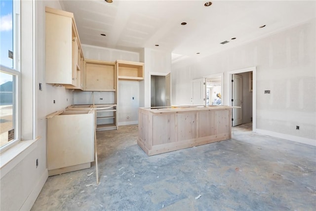 kitchen featuring plenty of natural light, light brown cabinetry, and a kitchen island