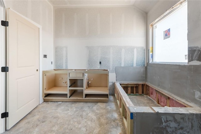 bathroom featuring lofted ceiling and concrete floors