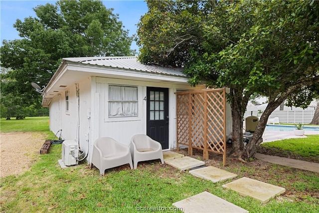 view of outbuilding featuring a yard and ac unit