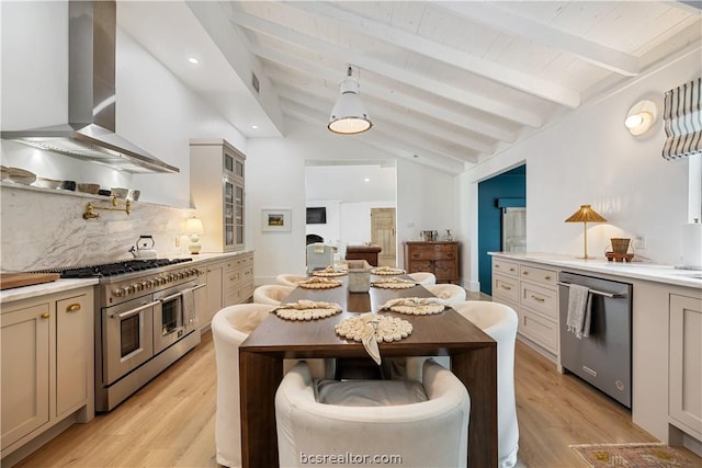 kitchen with light wood-type flooring, vaulted ceiling with beams, stainless steel appliances, and wall chimney exhaust hood