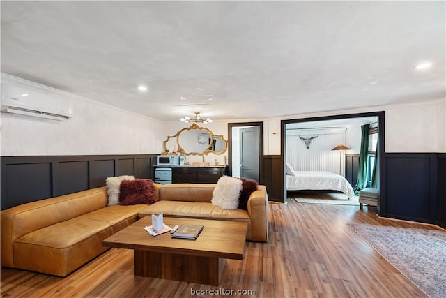 living room with crown molding, light hardwood / wood-style flooring, and a wall mounted air conditioner