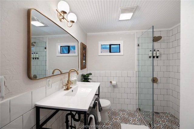 bathroom with an enclosed shower, toilet, vanity, tile walls, and ornamental molding