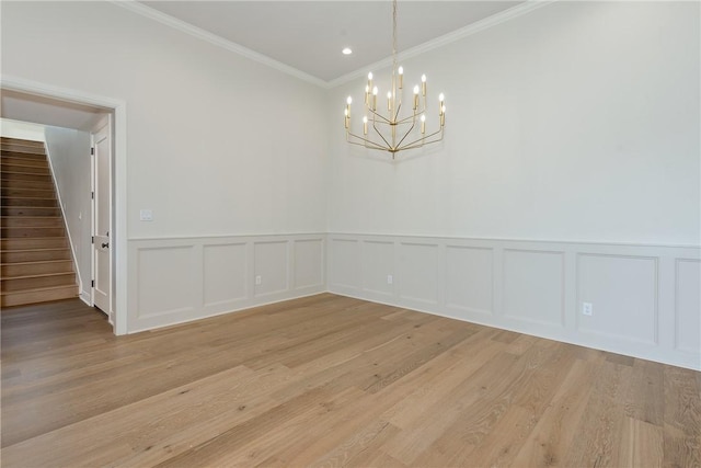 unfurnished dining area with crown molding, light wood-type flooring, and a notable chandelier