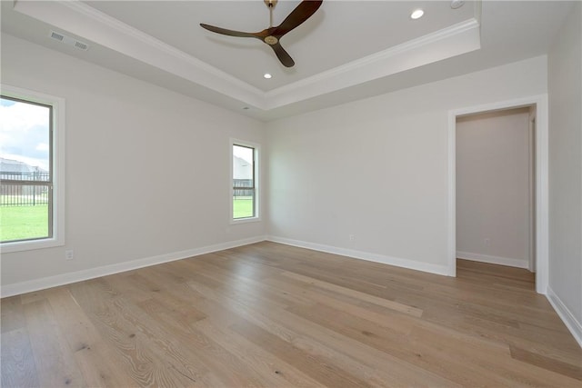 unfurnished room with a tray ceiling, light hardwood / wood-style flooring, ceiling fan, and crown molding