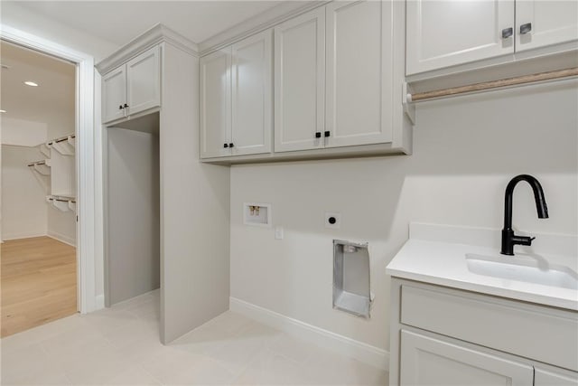 laundry area with sink, cabinets, washer hookup, electric dryer hookup, and light hardwood / wood-style floors