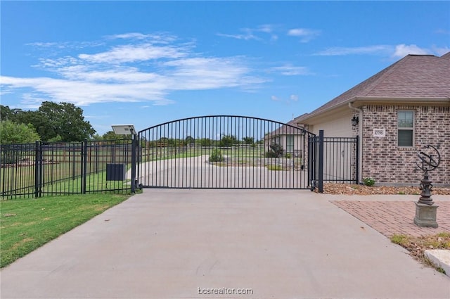 view of gate with a yard