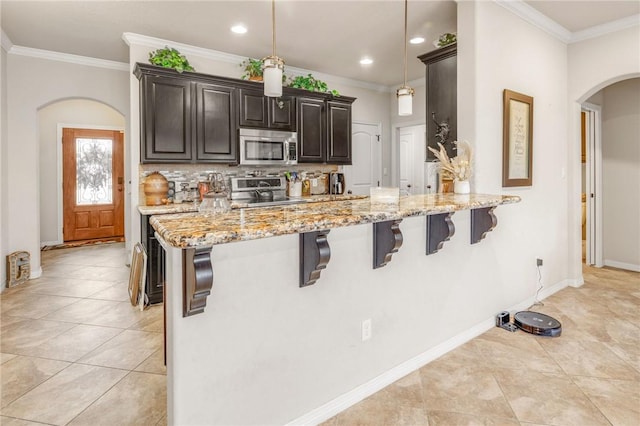 kitchen featuring hanging light fixtures, a breakfast bar area, kitchen peninsula, and appliances with stainless steel finishes