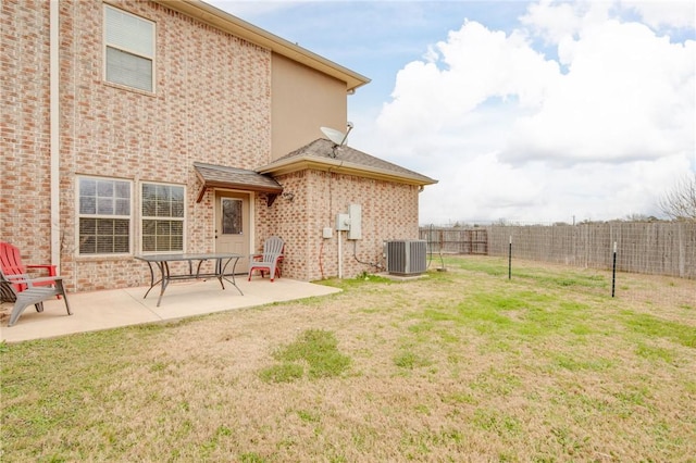 back of property with cooling unit, a lawn, and a patio