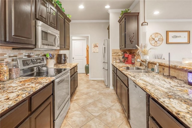 kitchen featuring ornamental molding, appliances with stainless steel finishes, sink, and decorative light fixtures