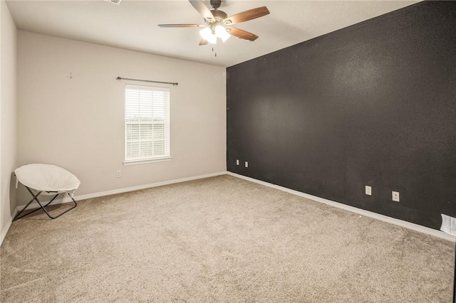 carpeted spare room featuring ceiling fan