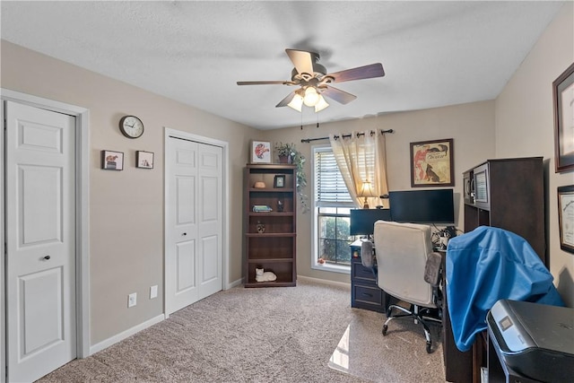 office area with a ceiling fan, carpet, and baseboards