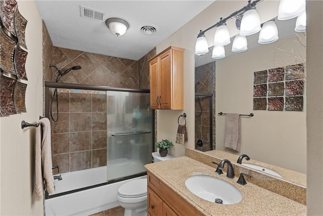 full bathroom featuring visible vents, vanity, toilet, and bath / shower combo with glass door