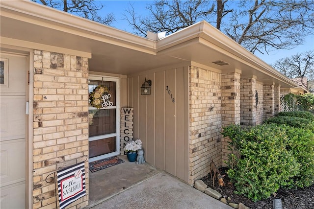 view of exterior entry featuring brick siding