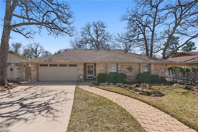 single story home with a garage, a front yard, concrete driveway, and brick siding