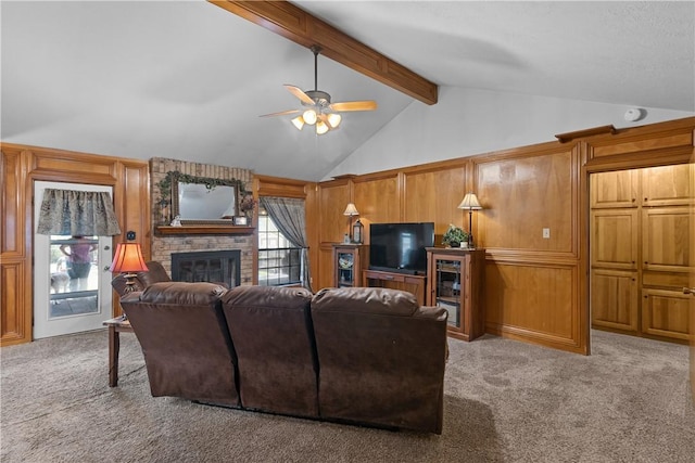 living area with vaulted ceiling with beams, a large fireplace, carpet, and a ceiling fan