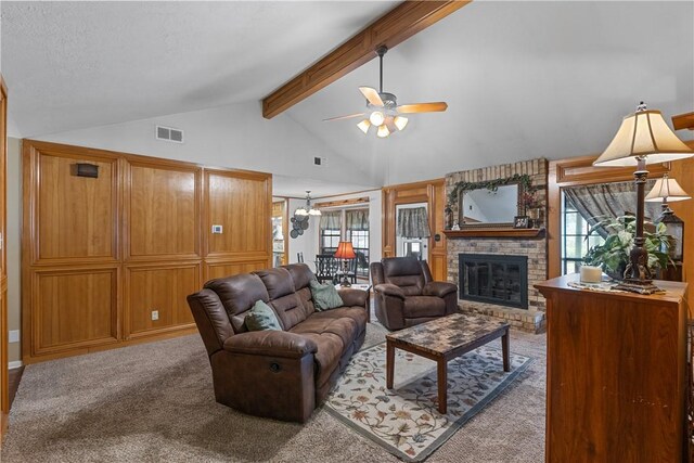 living room featuring carpet floors, beam ceiling, a fireplace, visible vents, and ceiling fan