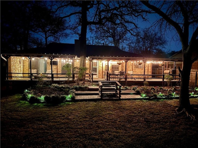 back of house at night with a deck