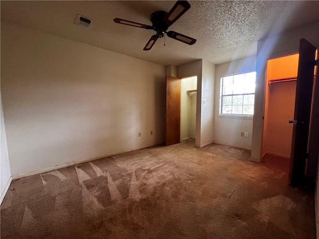 unfurnished bedroom with carpet, ceiling fan, and a textured ceiling