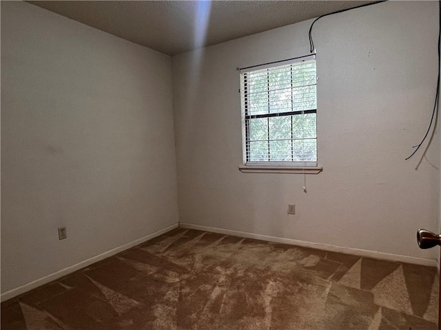 unfurnished room featuring dark colored carpet