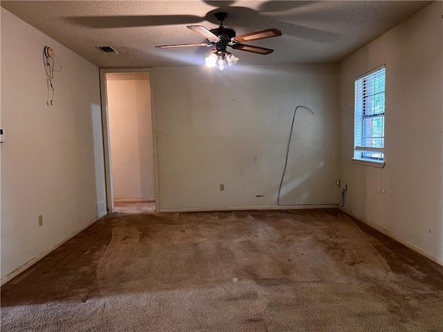 unfurnished room featuring a textured ceiling, carpet floors, and ceiling fan