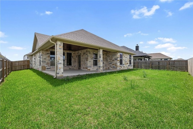2906 Spector Dr, Bryan, TX 77808 - back of property featuring a patio, a yard, stone siding, and a fenced backyard
