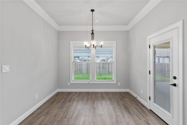 2906 Spector Dr, Bryan, TX 77808 - unfurnished dining area featuring an inviting chandelier, crown molding, visible vents, baseboards, and wood finished floors