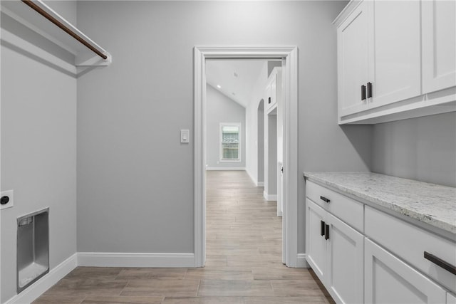 2906 Spector Dr, Bryan, TX 77808 - laundry area with hookup for an electric dryer, cabinet space, baseboards, and light wood-style floors