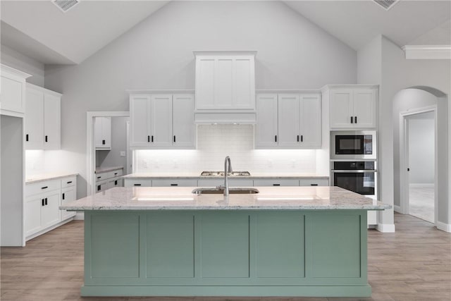 2906 Spector Dr, Bryan, TX 77808 - kitchen with appliances with stainless steel finishes, high vaulted ceiling, and white cabinets