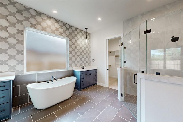 bathroom with tile patterned flooring, vanity, and plus walk in shower