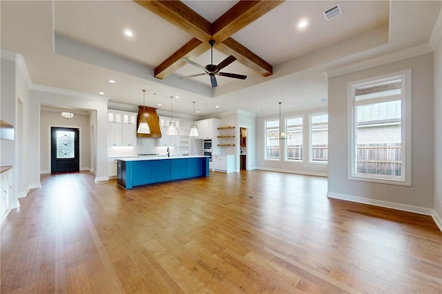 unfurnished living room with beamed ceiling, sink, coffered ceiling, ceiling fan, and light hardwood / wood-style flooring