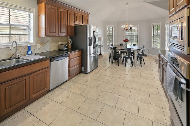 kitchen featuring a wealth of natural light, sink, a chandelier, decorative backsplash, and appliances with stainless steel finishes