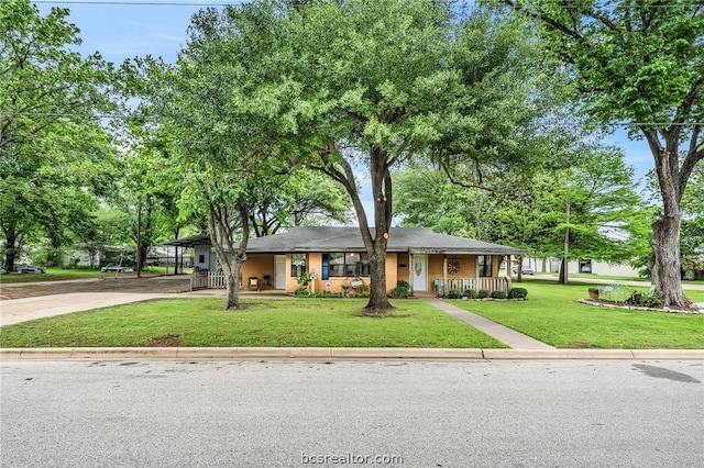 view of front of property with covered porch, a carport, and a front lawn