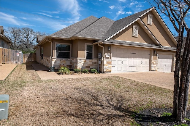 view of front facade with fence, stucco siding, concrete driveway, a garage, and stone siding