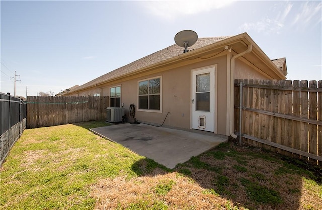 rear view of property featuring central AC, stucco siding, a yard, a fenced backyard, and a patio