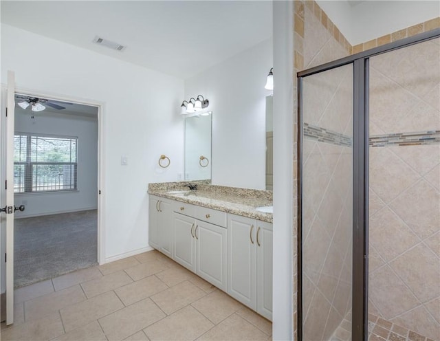 bathroom featuring a ceiling fan, visible vents, double vanity, a sink, and a shower stall