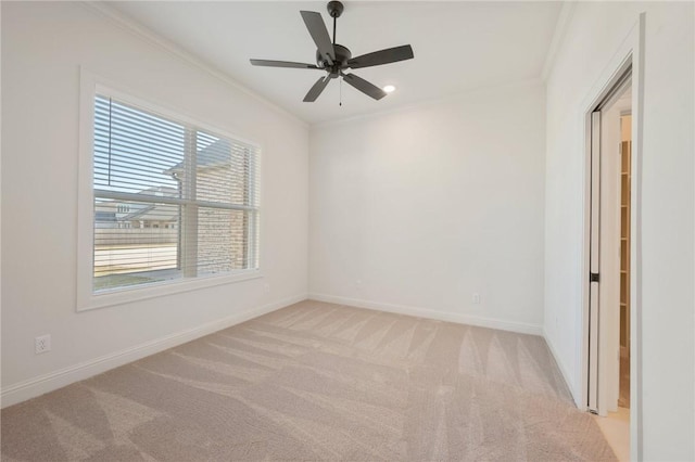 carpeted spare room with crown molding and ceiling fan