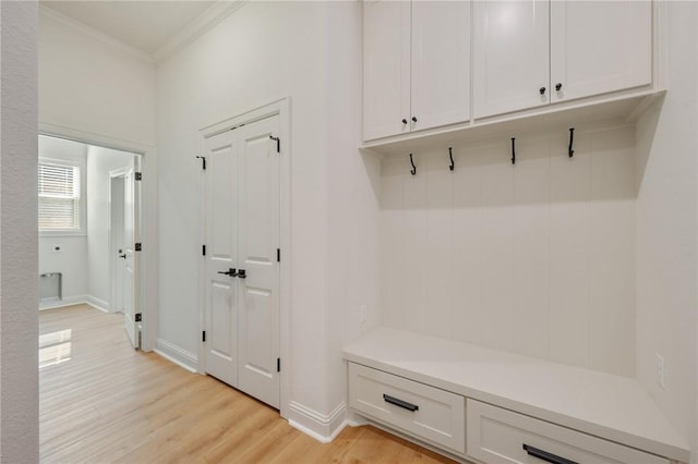 mudroom featuring ornamental molding and light wood-type flooring