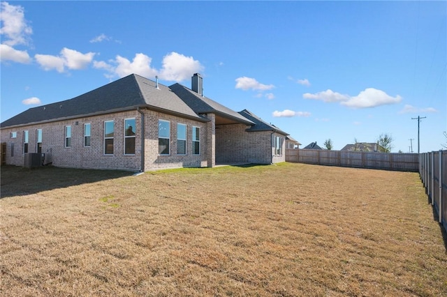 back of house featuring cooling unit and a lawn