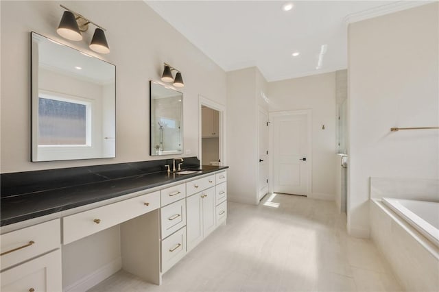 bathroom with vanity, ornamental molding, and a relaxing tiled tub