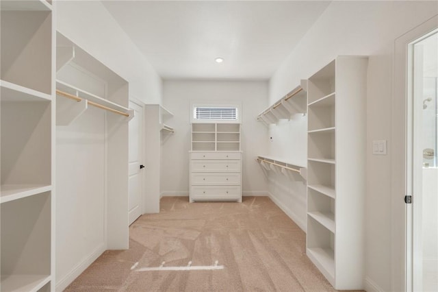 walk in closet featuring light colored carpet