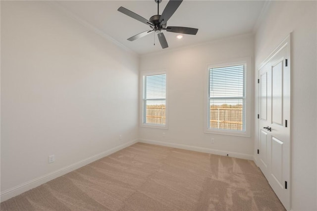 carpeted empty room featuring crown molding and ceiling fan