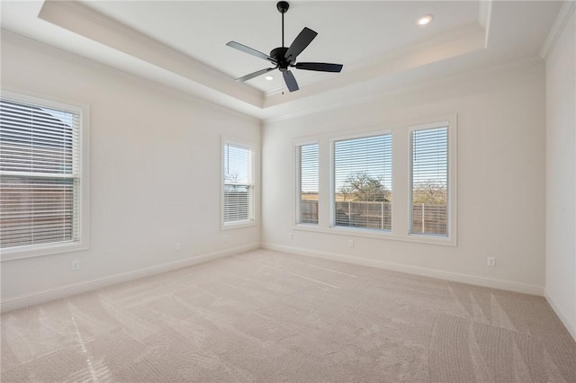 carpeted empty room with crown molding, a tray ceiling, and ceiling fan