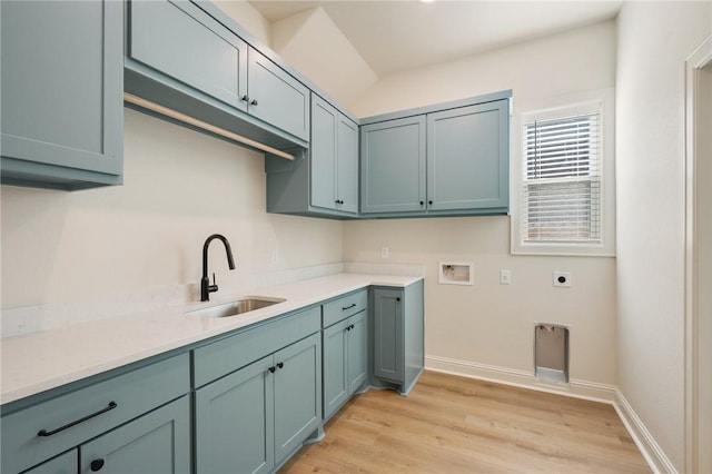 clothes washing area with sink, cabinets, washer hookup, light hardwood / wood-style floors, and electric dryer hookup