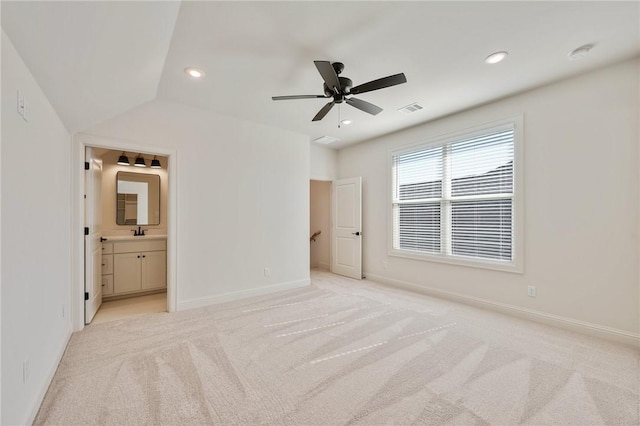 unfurnished bedroom featuring ceiling fan, ensuite bath, sink, and light carpet