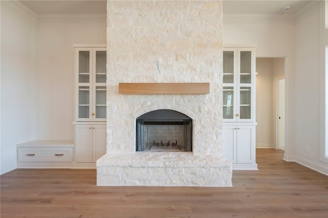 details featuring hardwood / wood-style floors, a stone fireplace, and ornamental molding