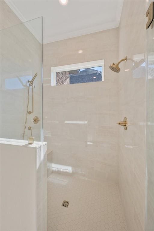 bathroom with a tile shower and crown molding