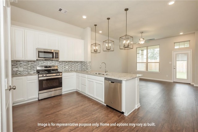 kitchen featuring ceiling fan, stainless steel appliances, light stone counters, dark hardwood / wood-style flooring, and white cabinets