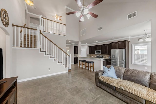 2609 Kimbolton Dr, College Station, TX 77845 - living area with stairs, a ceiling fan, baseboards, and a towering ceiling