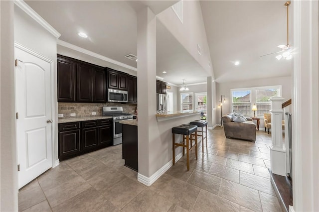 2609 Kimbolton Dr, College Station, TX 77845 - kitchen featuring stainless steel appliances, open floor plan, crown molding, baseboards, and a kitchen breakfast bar